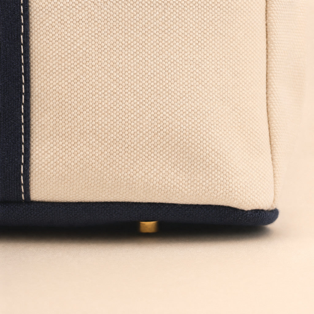 Detail of the Camille’s soft lower-corner pleat and Navy base trim.