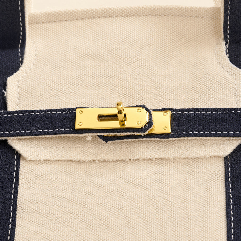 Close-up of the Camille’s gold center fitting on its Navy front belt.