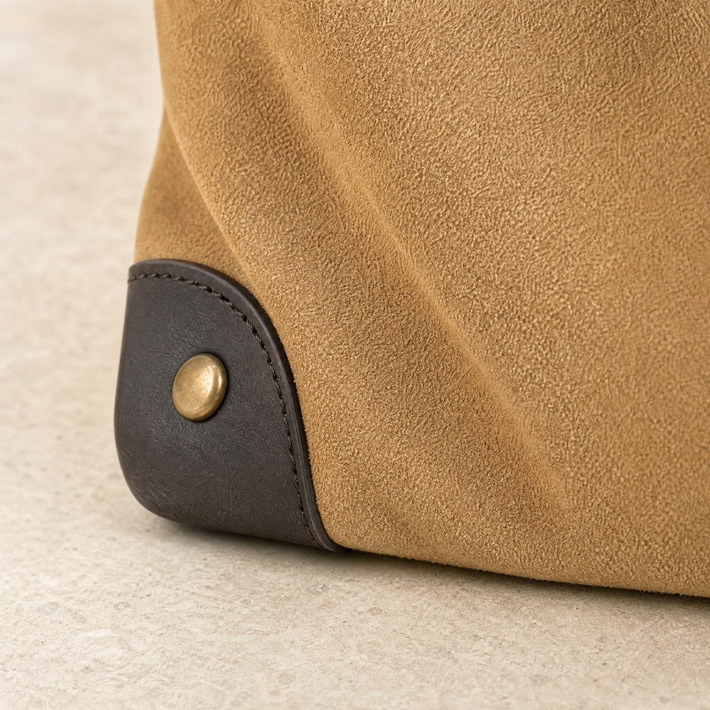 Close-up of the Juliette’s leather corner cap, curved seam and brass stud.