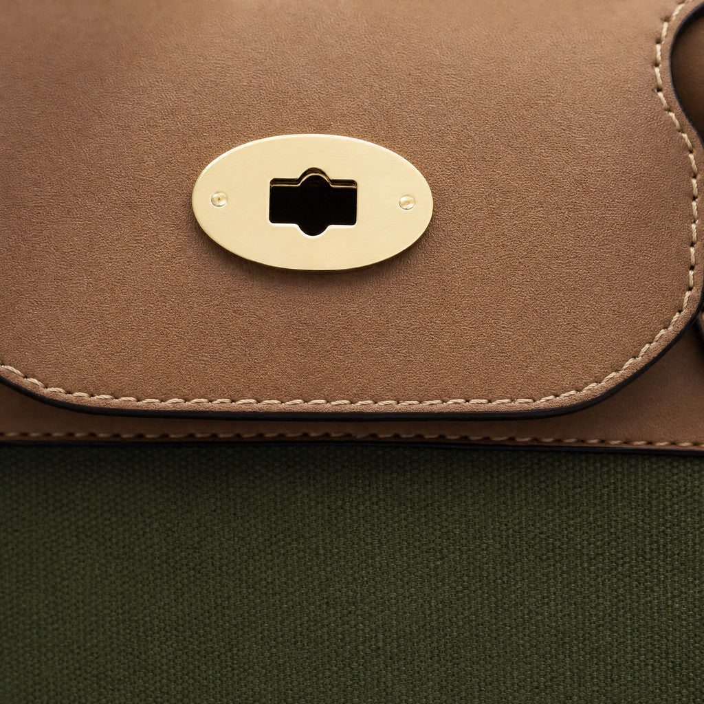 Close-up of the Eleanor Weekender’s horizontal oval gold fitting on its leather flap.